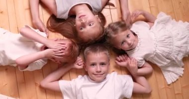 Eğlenceli aile tatili. Mutlu çocuklar, tepeden tırnağa yerde yatıyor.