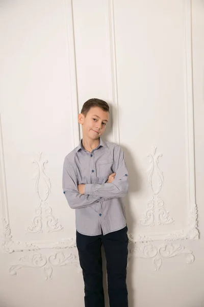 白い壁に向かって屋外に立つハンサムな男の子の肖像画 — ストック写真