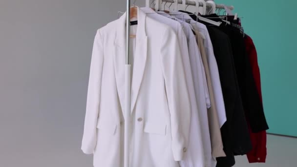 A escolha de roupas em um rack. Cremalheira guarda-roupa com roupas elegantes — Vídeo de Stock