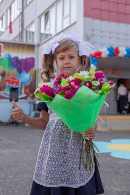 Moskova, Rusya, Eylül. 1 Eylül. Bilgi Günü 'nde. Birinci sınıf. Bir buket çiçekli okul üniformalı kız.