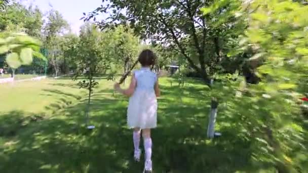 子供の頃は自然に近い 周りの木 テキスト用のスペース ドレス姿の可愛い娘が庭を駆け抜けて公園へ スローモーション — ストック動画