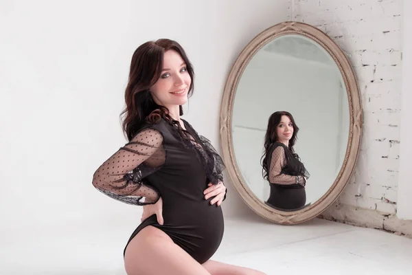 Foto Una Atractiva Mujer Embarazada Cuerpo Negro Espejo Fondo Blanco —  Fotos de Stock