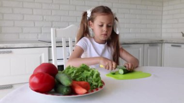 Küçük kız salatalık keser. Mutfakta Yeşil Salata Hazırlayan Çocuk, Sebze Kesen Kız Sağlıklı Yemek