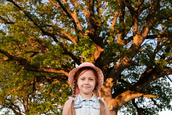 在一棵大树旁边的小女孩 靠近绿色大老橡木的孩子 巨大的树 复制空间 — 图库照片