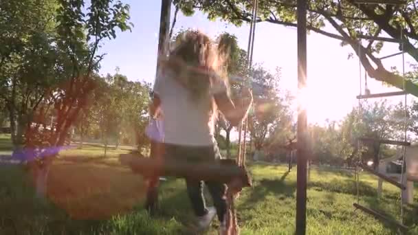 Ein Süßes Mädchen Mit Langen Haaren Reitet Auf Einer Schaukel — Stockvideo