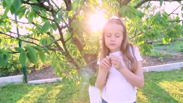 정원에서 노을에 귀여운 소녀의 자녀는 행복과 긍정적 감정을 나타낸다 — 비디오