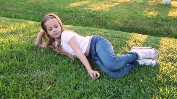 Szczęśliwa Dziewczynka Leżąca Zielonej Trawie Letnim Parku Mała Słodka Dziewczyna — Wideo stockowe