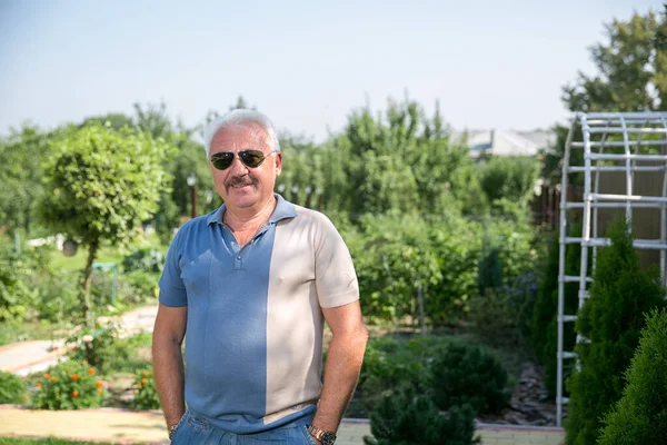 Yazın güneş gözlüklü, kır saçlı adam.