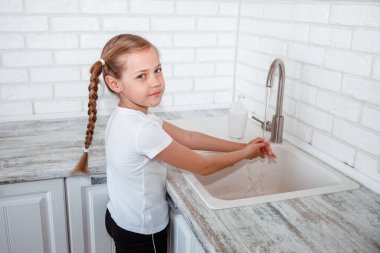 Çocuk ellerini sabun ve suyla yıkıyor. Çocuğun hijyeni.