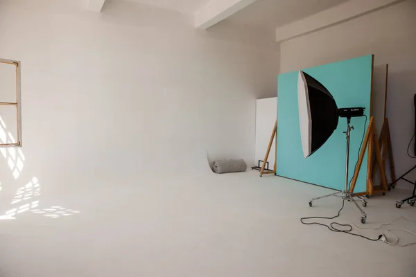 Empty photo studio with lighting equipment. Photo studio with large white wall