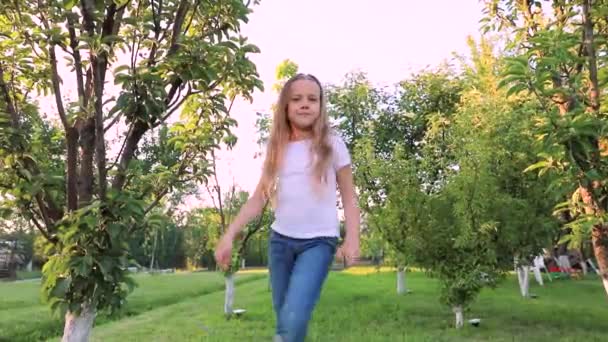 Bambina dolce con i capelli lunghi che balla nel parco — Video Stock