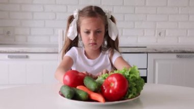 Küçük kız sebze yemek istemiyor. Çocuk sinirlenir ve arkasını döner..