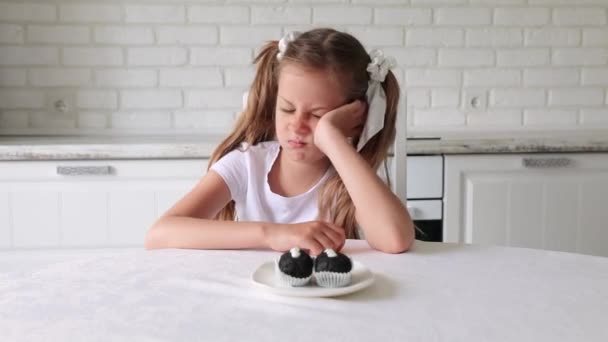 Un niño divertido, una chica de aspecto europeo, no le gusta comer chocolate. — Vídeos de Stock