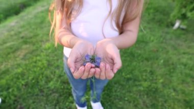 Bir çocuğun ellerinde çiçek