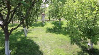 Elbiseli küçük güzel kız bahçede koşuyor, park ediyor.