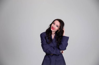 Erkek gibi giyinmiş olarak. Gri arka planda güzel erkek ceketi. Portre