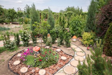 Bahçede çiçekler ve taşlar. Bahçede çelenk.