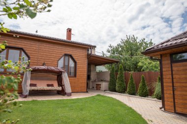 Garden 'daki arka bahçe avlusu. Yeşil bahçeli bir ev. Arka bahçede ahşap bir ev..