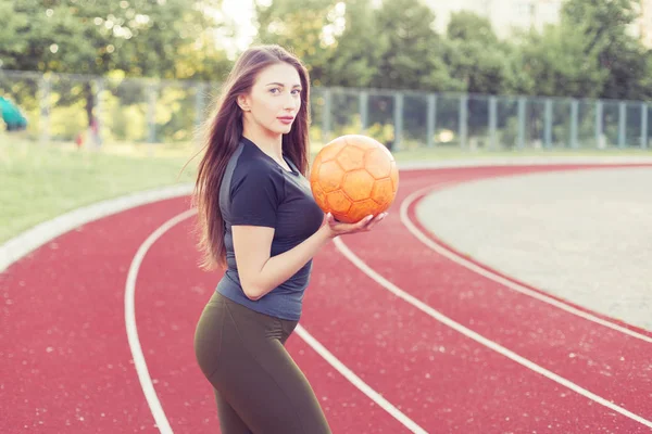 競技場に彼女の手にボールを持つ若い女性の肖像画 — ストック写真