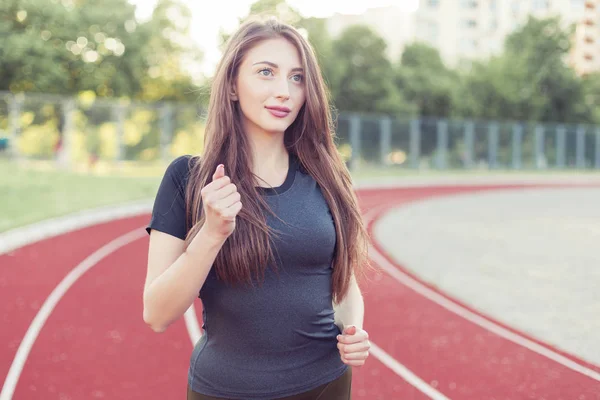 若くてきれいな女性がスタジアムを通る — ストック写真