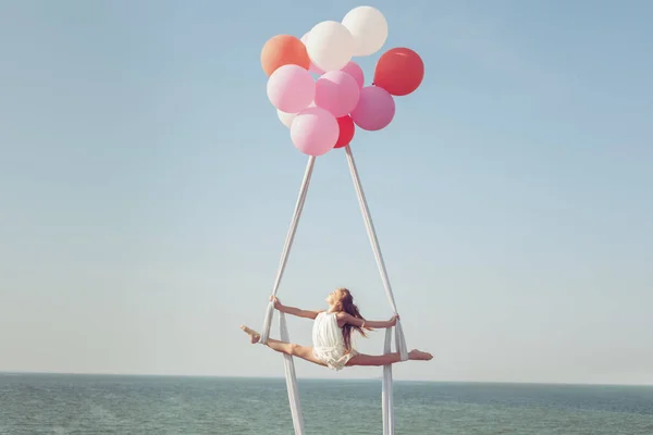 Дівчина Робить Шпагат Полотні Над Морем Повітряні Кульки Тримають Полотно — стокове фото