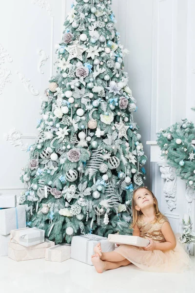 Menina Senta Perto Uma Árvore Natal Segurando Presente — Fotografia de Stock