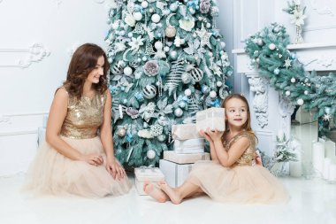 Mutlu anne ve kızı Noel ağacı yakın. Bir hediye ile bir kutu tutan kız.