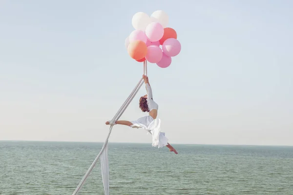 Junge Frau Schwebt Auf Luftballons Über Dem Meer — Stockfoto