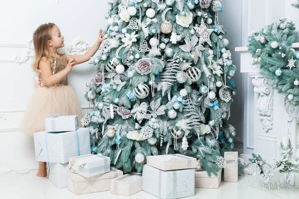 Klein Meisje Een Mooie Jurk Hangt Decoraties Kerstboom — Stockfoto