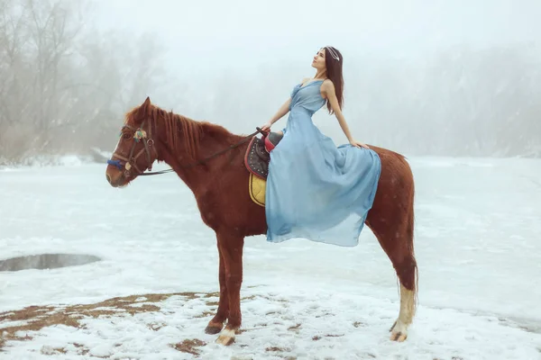 在冰湖边骑马的美丽的黑发女郎 — 图库照片
