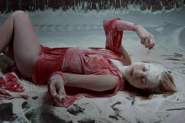 Kobieta leży w mąki na podłodze. — Zdjęcie stockowe