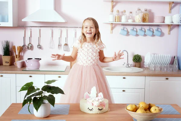 Klein meisje in een mooie jurk staat in de keuken. — Stockfoto