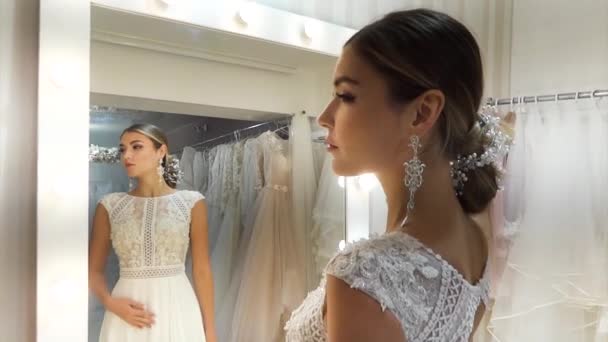 美丽的年轻女子测量在沙龙的婚纱 — 图库视频影像