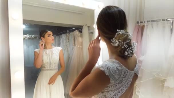 Mladá Krásná Nevěsta Stojí Zrcadla Zkouší Šaty — Stock video