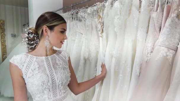 Hermosa Novia Joven Elige Vestidos Novia Una Percha Salón — Vídeos de Stock