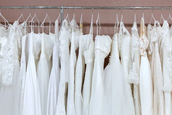 W salonie ślubnym jest wiele pięknych sukienek ślubnych. — Zdjęcie stockowe