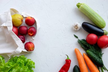 Sebze ve meyve lerle dolu tekstil poşeti, beyaza üstte
