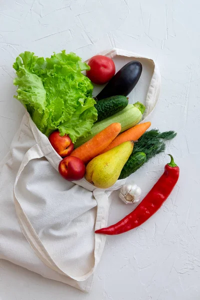 Textile bag filled with vegetables and fruits, top view on white — Stock Photo, Image