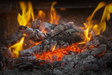 Siyah arkaplanda kıvılcımlar saçan bir ateş alevi