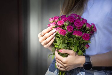 Şehir sokaklarında ellerinde güllerle şık genç bir sarışın..