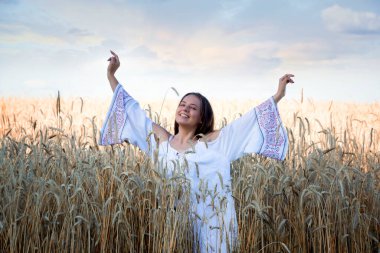 Gün batımında bir tarlada halk kostümü giymiş güzel bir kız..