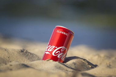 Gomel, Belarus - 2 Eylül 2020: Coca Cola, Fanta, Sprite, Schwepps in cans and bottle, arka planda bir yaz plajında meşrubat.