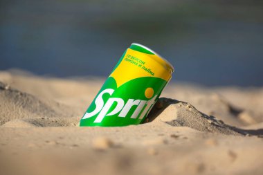 Gomel, Belarus - 2 Eylül 2020: Coca Cola, Fanta, Sprite, Schwepps in cans and bottle, arka planda bir yaz plajında meşrubat.