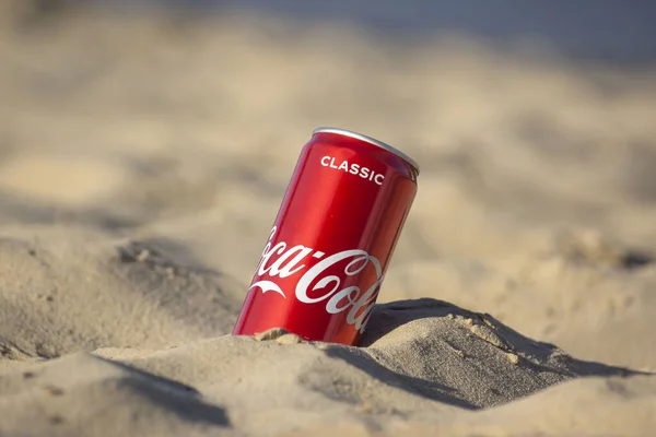 Gomel, Belarus - 2 Eylül 2020: Coca Cola, Fanta, Sprite, Schwepps in cans and bottle, arka planda bir yaz plajında meşrubat.