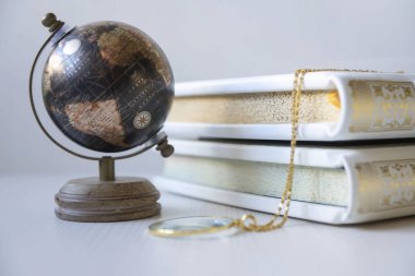 Beyaz kitaplık ve kitap standında küçük bir küre ve çeşitli küçük şeyler..