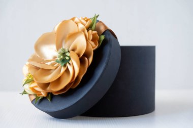 Arkaplanda suni çiçeklerle süslenmiş bir hediye kutusu..