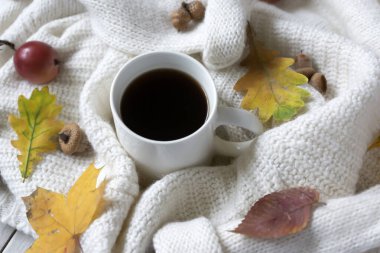 Bir fincan sıcak kahve ve renkli sonbahar yaprakları ve daha sıcacık bir görünüş. Merhaba, Autumn..