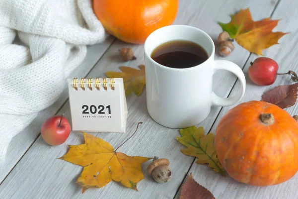 Calendar for 2021 and a cup of hot coffee, colorful autumn leaves and much more, a cozy warm look. Hello, Autumn.
