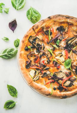 Taze pişmiş sebze ile İtalyan Vejetaryen pizza, beyaz mermer masa üzerinde taze fesleğen