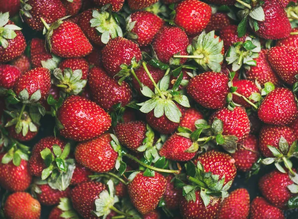 Fresh strawberries texture, wallpaper and background. Wet strawberries with leaves